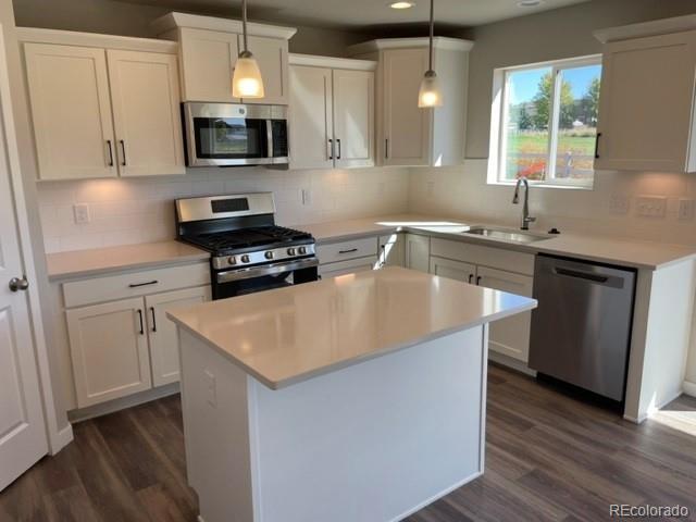 534 Ryan Avenue Fort Lupton, CO 80621 - Photo 2 of 25 a kitchen with stainless steel appliances a sink a stove a microwave a center island and cabinets