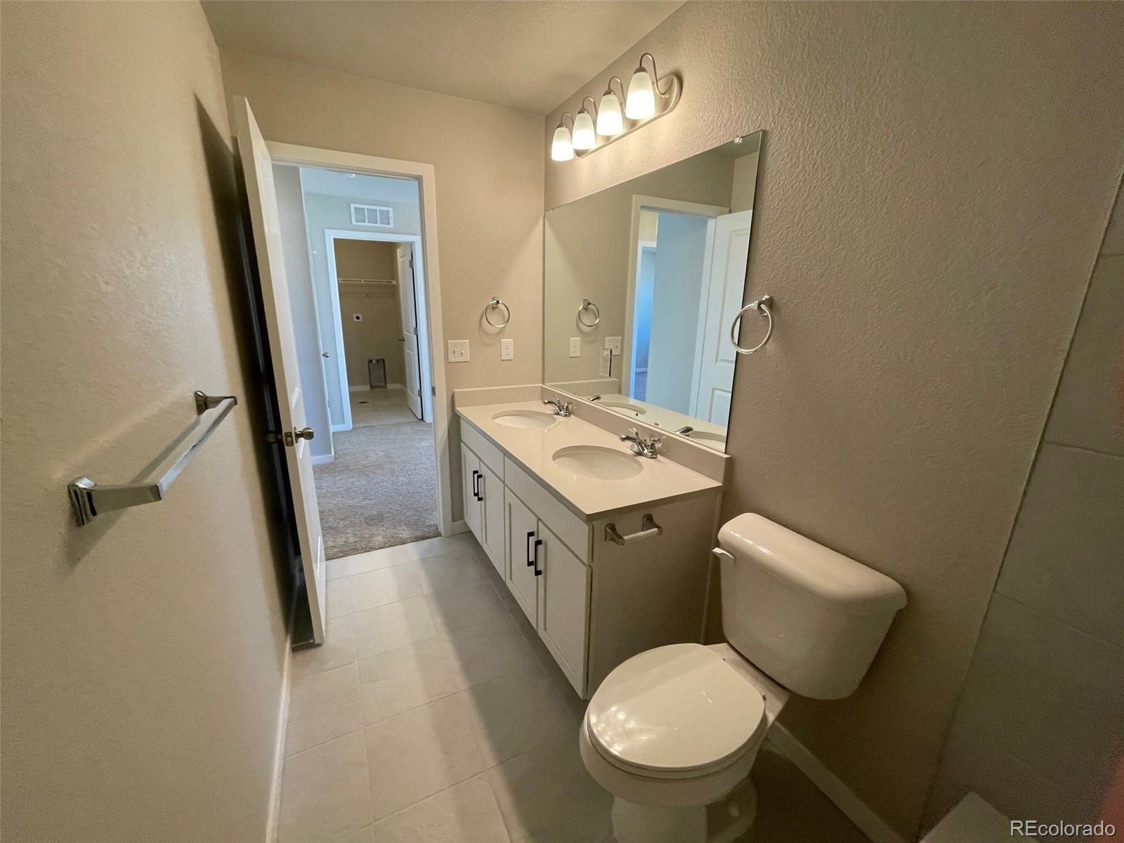 534 Ryan Avenue Fort Lupton, CO 80621 - Photo 23 of 25 a bathroom with a toilet sink and mirror