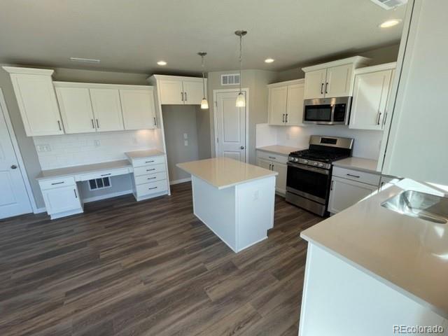 534 Ryan Avenue Fort Lupton, CO 80621 - Photo 3 of 25 a large kitchen with stainless steel appliances granite countertop a stove top oven a sink dishwasher and a refrigerator with wooden floor