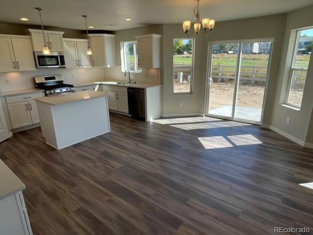 534 Ryan Avenue Fort Lupton, CO 80621 - Photo 4 of 25 a kitchen with stainless steel appliances granite countertop a sink stove and wooden floor