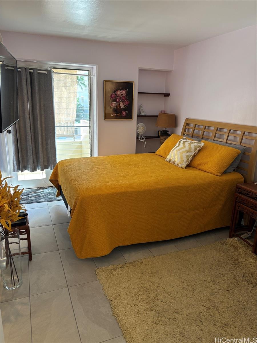 225 Kaʻiulani Avenue, Unit 402 Honolulu, HI 96815 - Photo 11 of 16 a bedroom with a bed and a table in it