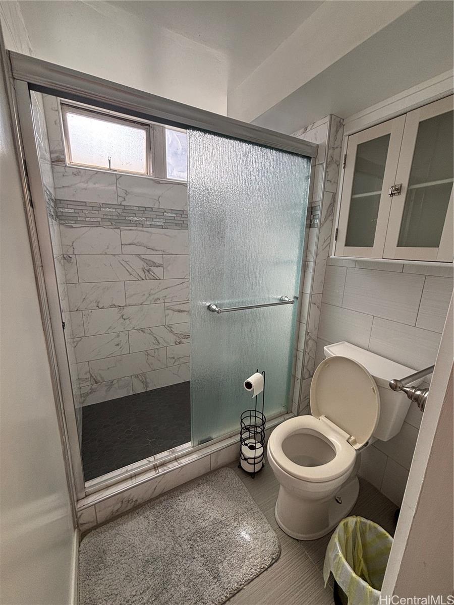 225 Kaʻiulani Avenue, Unit 402 Honolulu, HI 96815 - Photo 14 of 16 a bathroom with a toilet a sink and a mirror