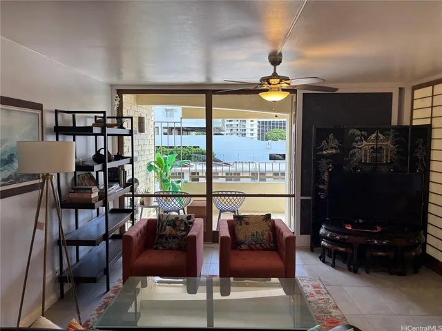 a living room with furniture a lamp and a floor to ceiling window