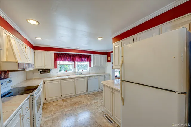 a kitchen with a refrigerator a stove a sink dishwasher and cabinets