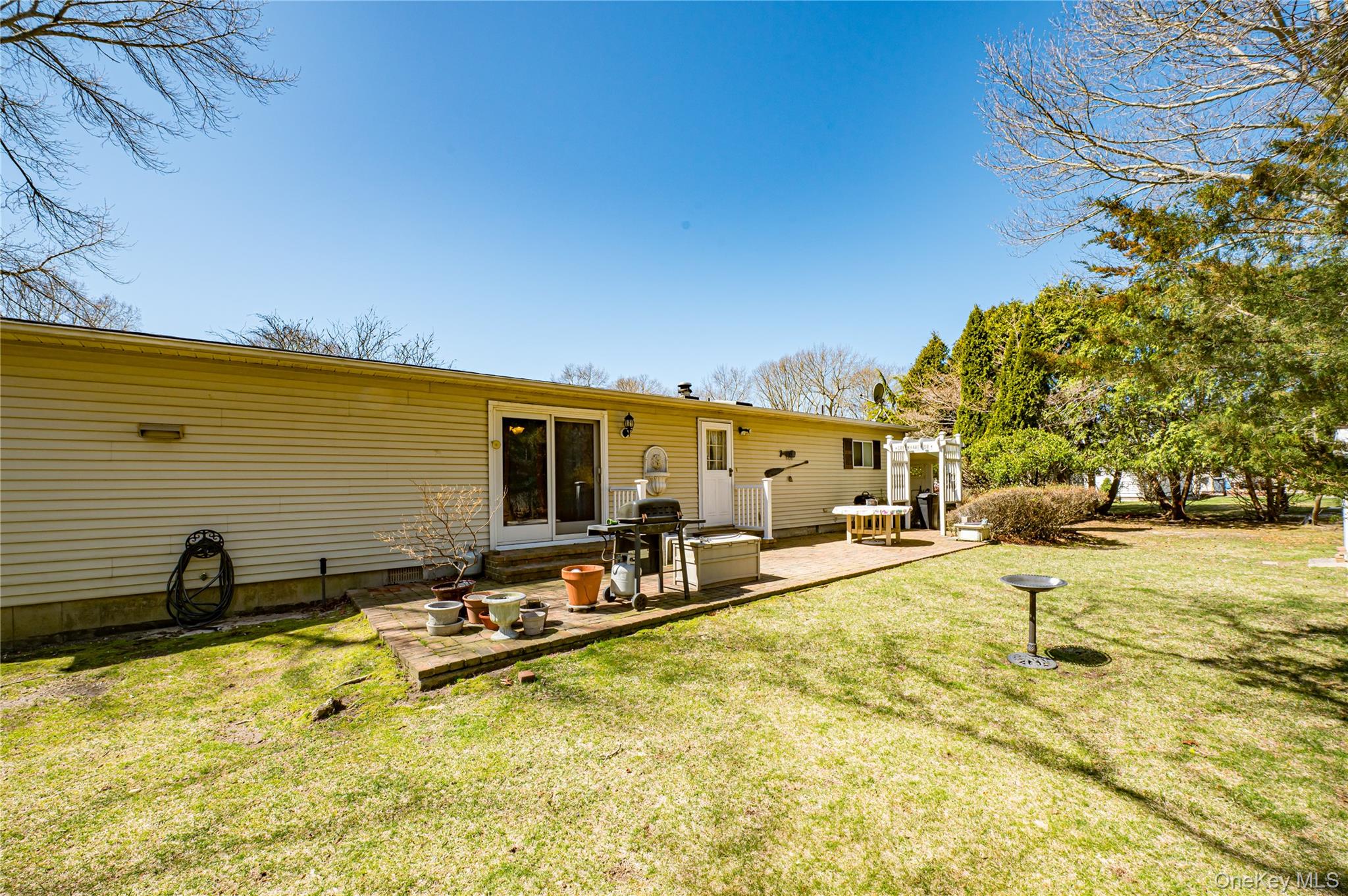 1407 Middle Road, Unit 6 Calverton, NY 11933 - Photo 25 of 25 a view of a swimming pool with a lawn chairs under an umbrella