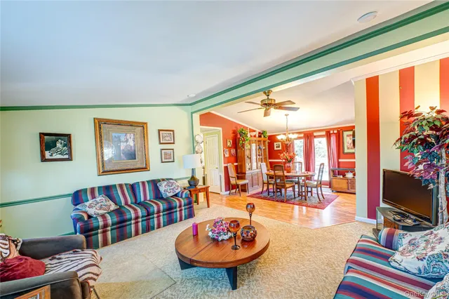 a living room with furniture a flat screen tv and a floor to ceiling window