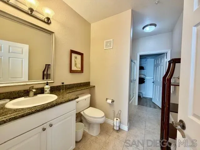 a spacious bathroom with a granite countertop sink toilet and shower