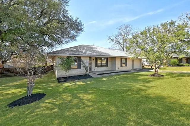 a view of a house with a yard and sitting area