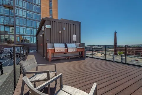 a view of a roof deck with wooden floor and iron stairs