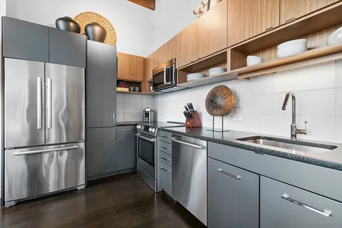 a kitchen with stainless steel appliances granite countertop a refrigerator a sink and a stove