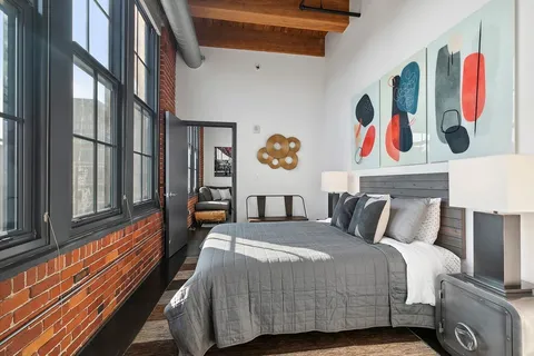 a bedroom with a bed and paintings on the wall