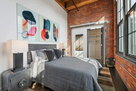 a bedroom with a bed and wooden floor