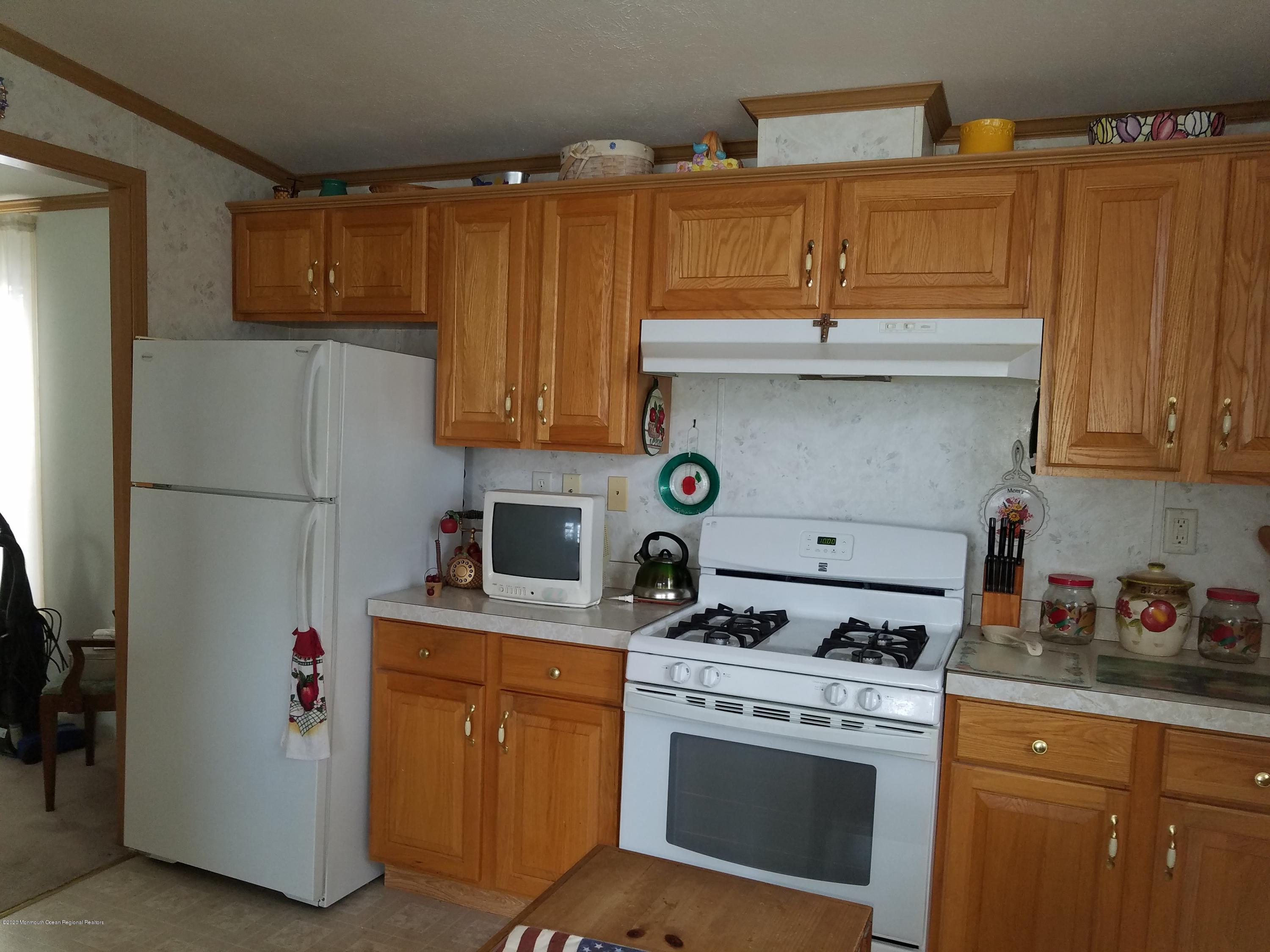74 Pine Ridge Boulevard Whiting, NJ 08759 - Photo 9 of 28 a kitchen with stainless steel appliances granite countertop a stove and a refrigerator with cabinets