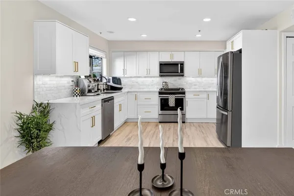 a kitchen with stainless steel appliances a sink stove and refrigerator