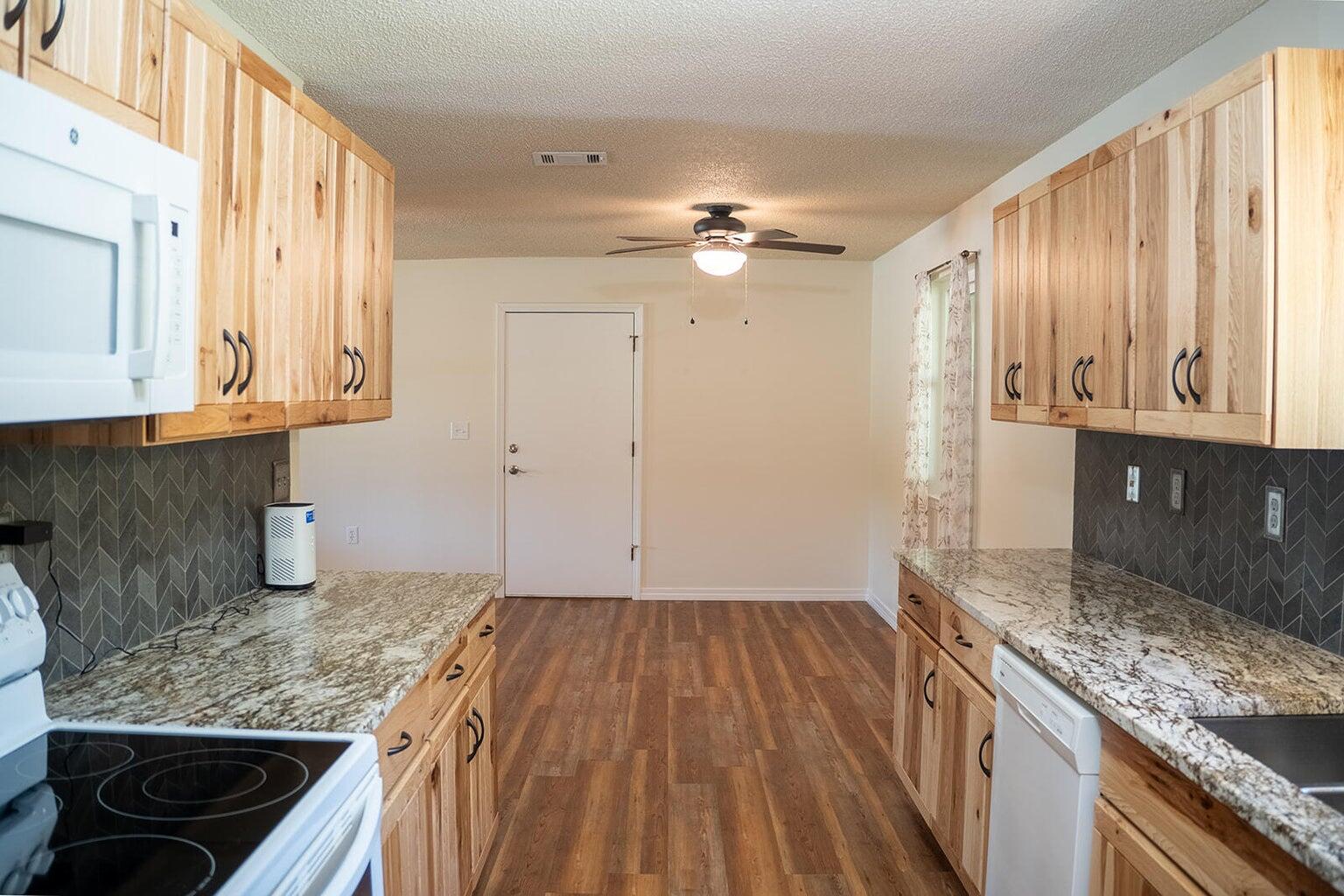 4868 Griffith Mill Road Holt, FL 32564 - Photo 23 of 32 a kitchen with granite countertop a sink stove and cabinets