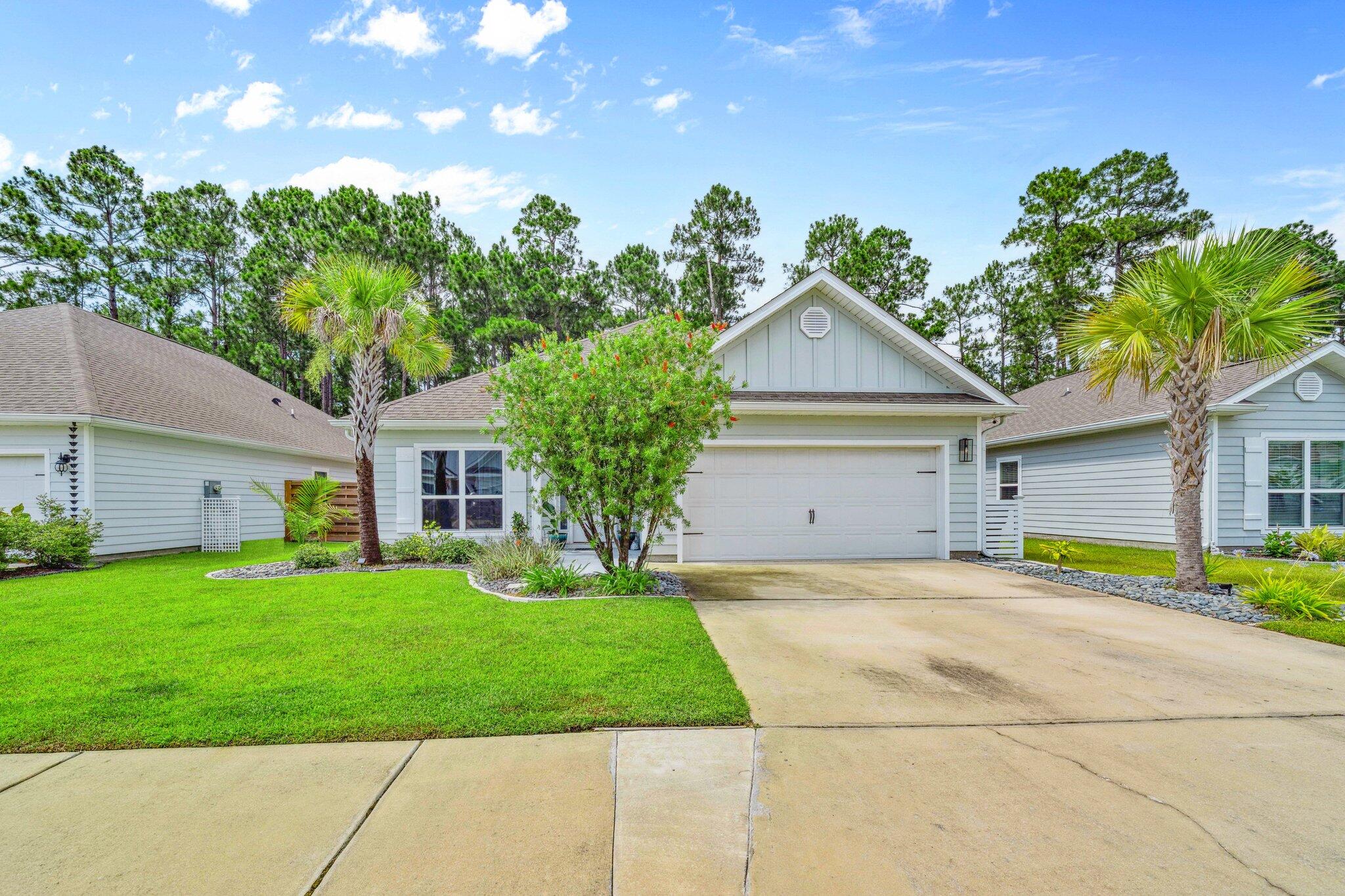 199 Southern Pnes Road Santa Rosa Beach, FL 32459 - Photo 1 of 44 a front view of a house with a garden and trees