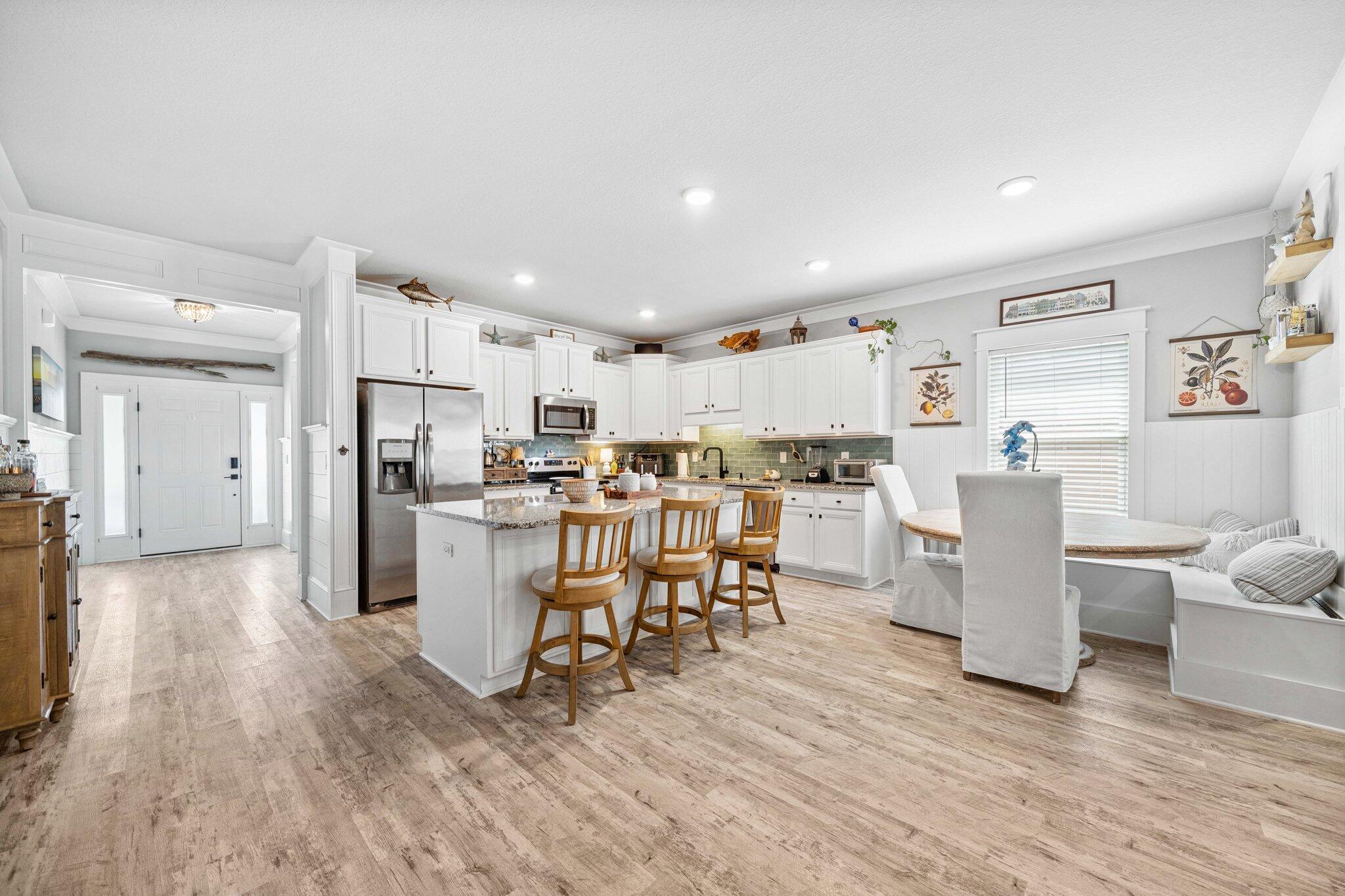 199 Southern Pnes Road Santa Rosa Beach, FL 32459 - Photo 11 of 44 a kitchen with a dining table chairs refrigerator and cabinets