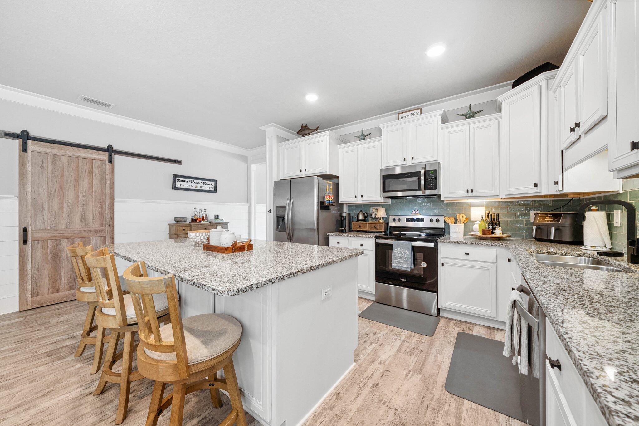 199 Southern Pnes Road Santa Rosa Beach, FL 32459 - Photo 13 of 44 a kitchen with granite countertop white cabinets and stainless steel appliances