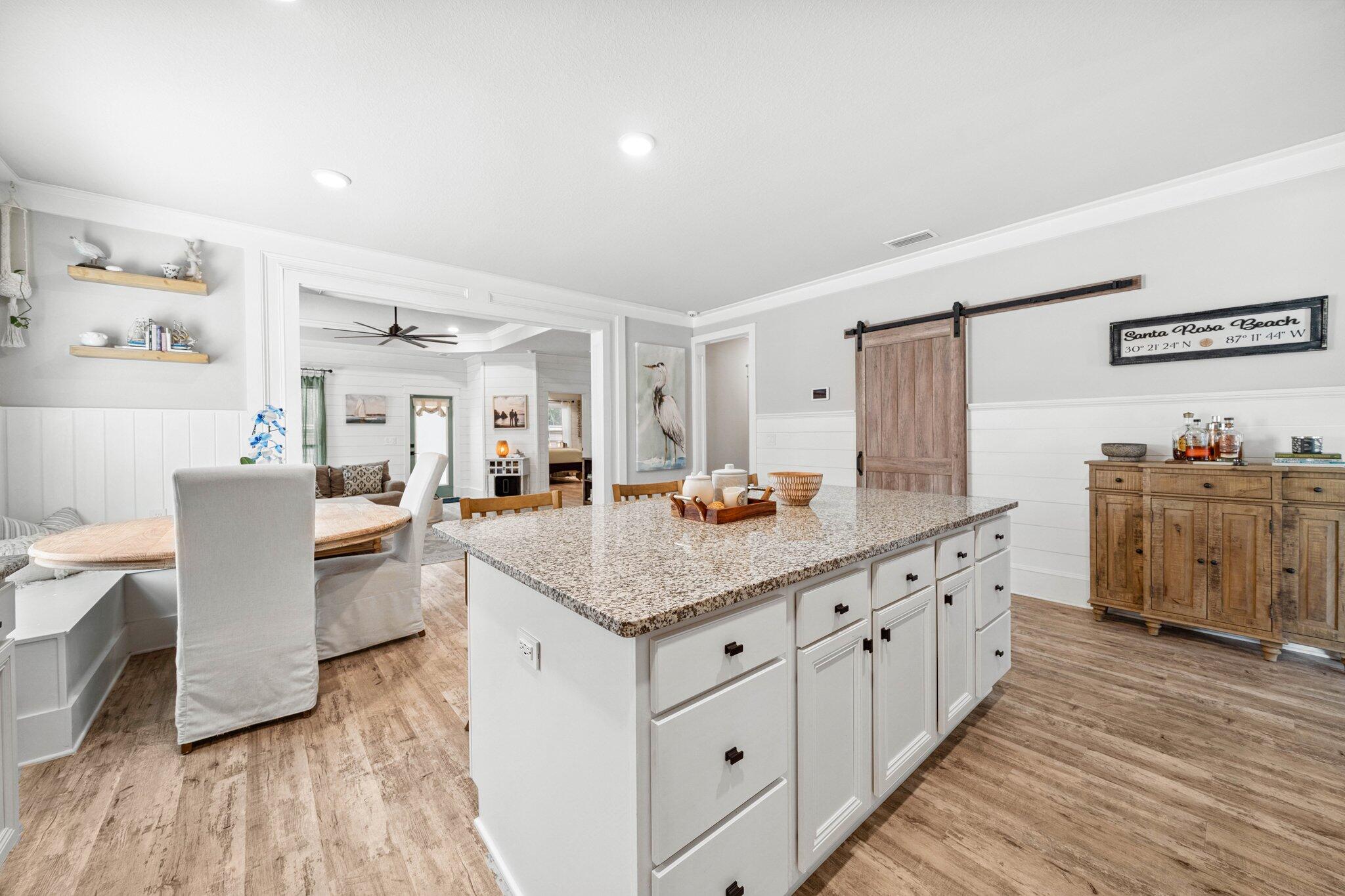 199 Southern Pnes Road Santa Rosa Beach, FL 32459 - Photo 14 of 44 a kitchen with kitchen island granite countertop a sink cabinets and wooden floor