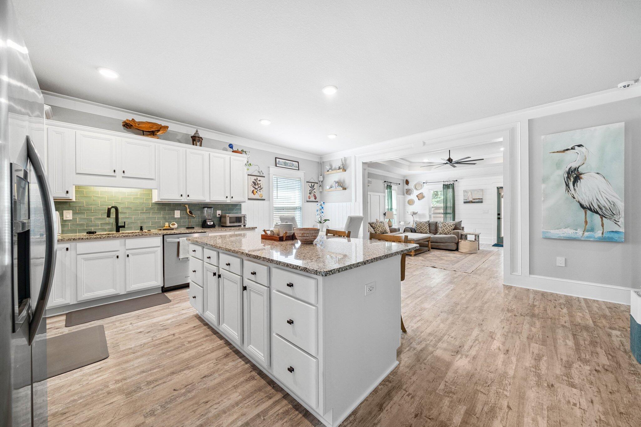 199 Southern Pnes Road Santa Rosa Beach, FL 32459 - Photo 8 of 44 a kitchen with stainless steel appliances kitchen island wooden floors and white cabinets