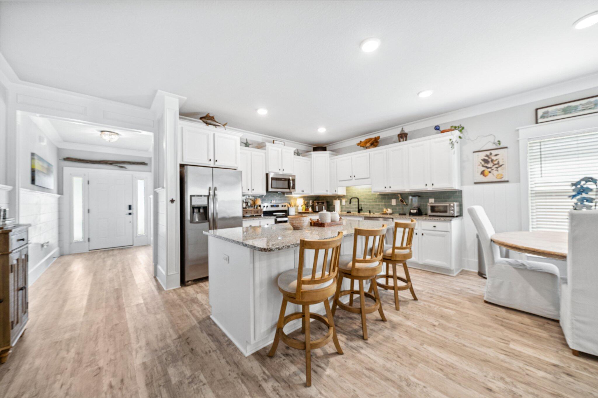 199 Southern Pnes Road Santa Rosa Beach, FL 32459 - Photo 10 of 44 a kitchen with kitchen island wooden floors white appliances and cabinets