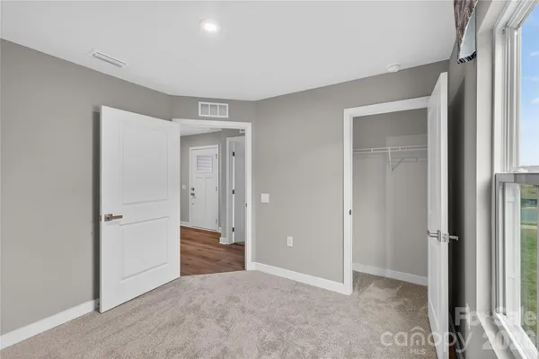an empty room with closet and a bathroom