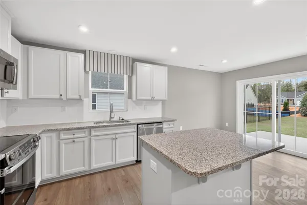 a kitchen with a sink window and cabinets