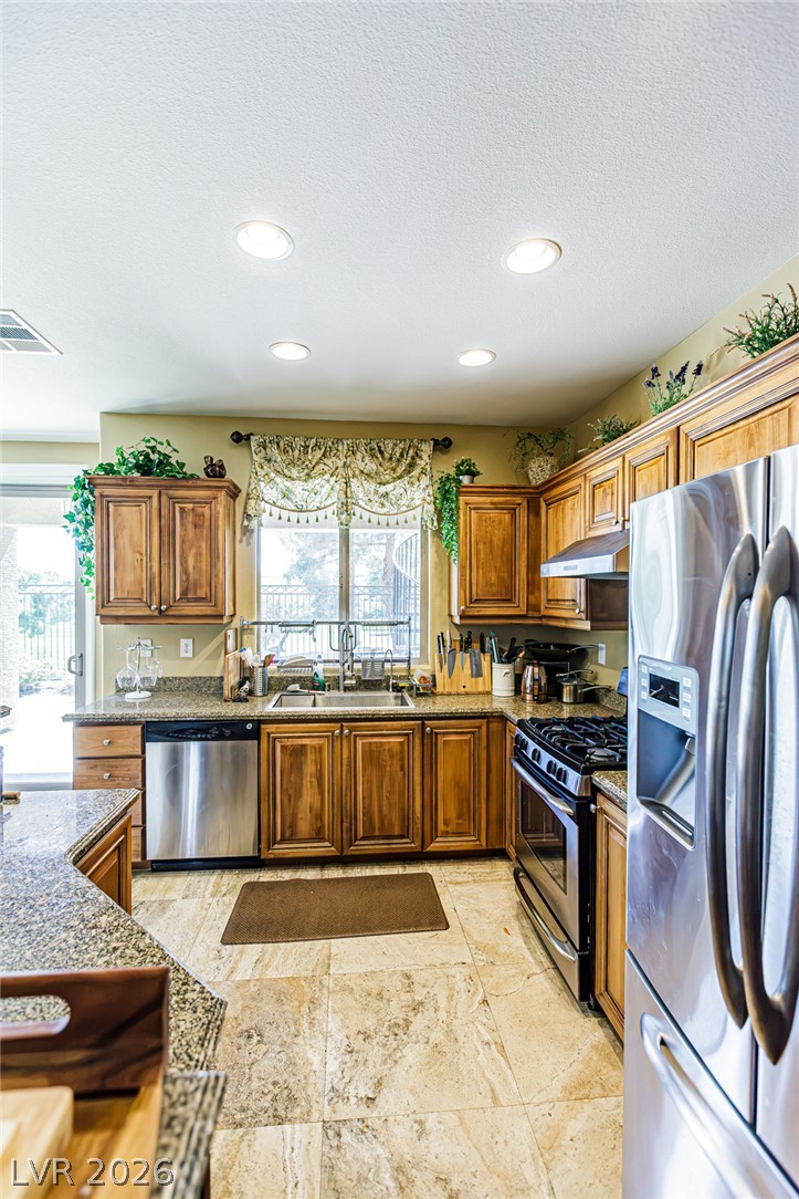 75 Tall Ruff Drive Las Vegas, NV 89148 - Photo 15 of 64 Classic wooden cabinetry and granite countertops ground this inviting culinary space.