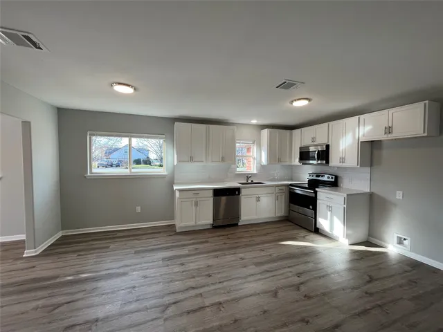 a kitchen with stainless steel appliances granite countertop a stove a sink and a refrigerator