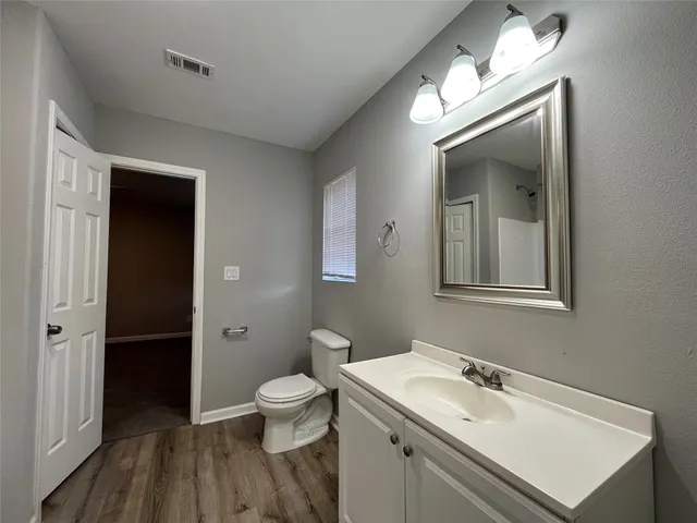 a bathroom with a sink vanity granite and toilet