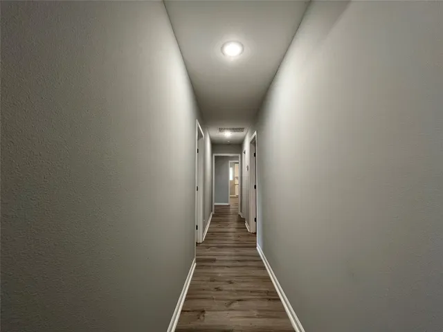 a view of a hallway with wooden floor
