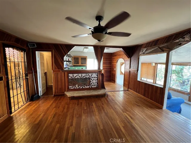 a view of a room with wooden floor fan and windows