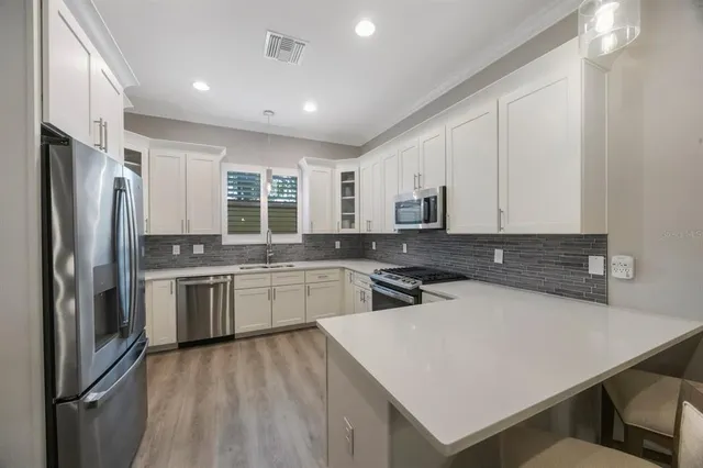 a open kitchen with white cabinets and stainless steel appliances
