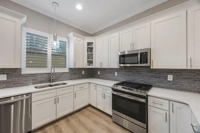 a kitchen with stainless steel appliances a refrigerator sink and microwave