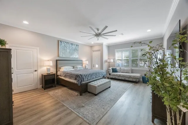 a spacious bedroom with a bed and ceiling fan