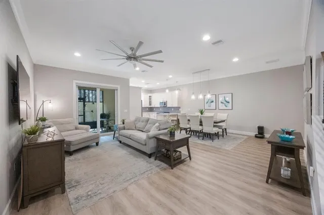 a living room with furniture a flat screen tv and kitchen view