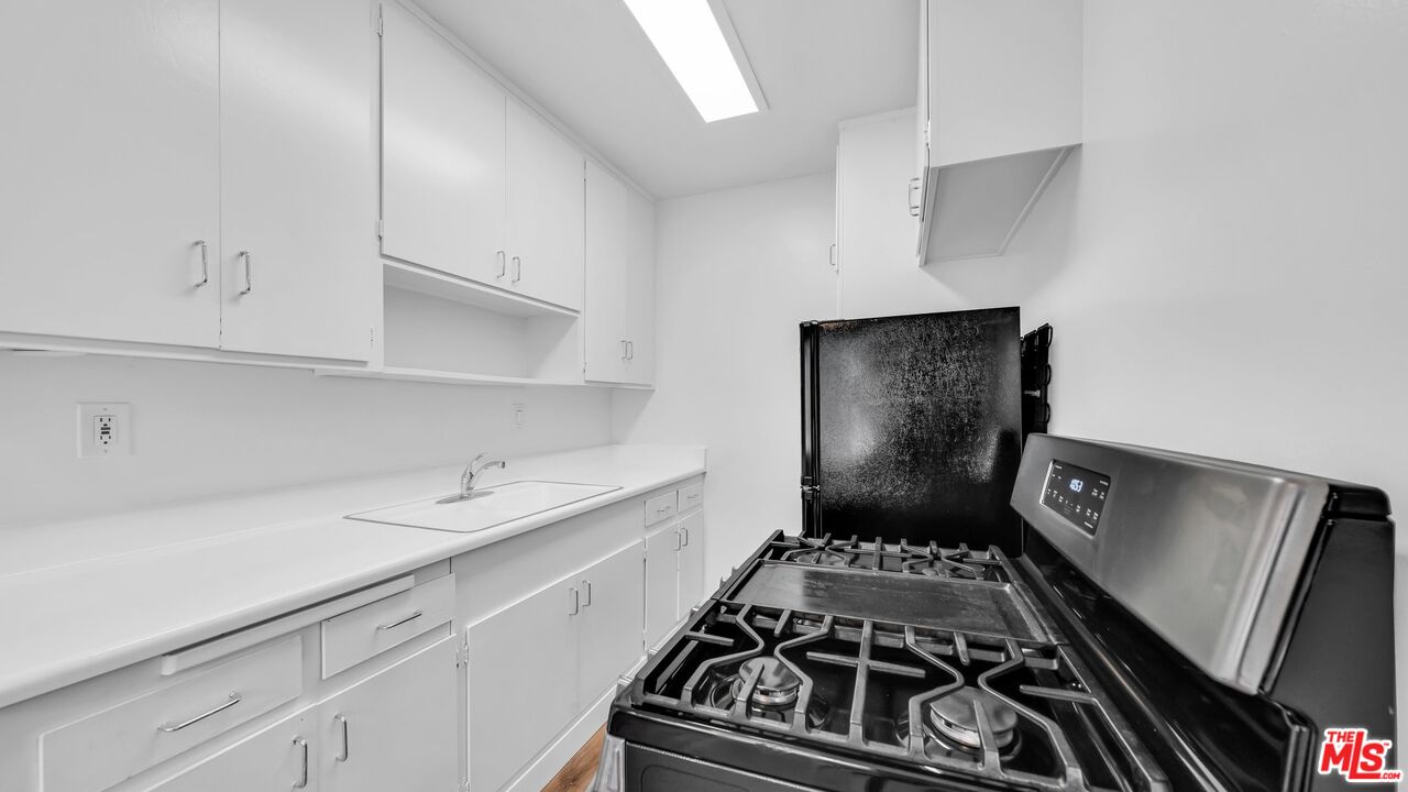 510 Pacific Avenue, Unit 6 Venice, CA 90291 - Photo 4 of 14 a kitchen with a stove and a white cabinets