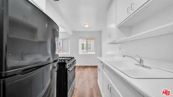 a kitchen with a sink and large windows