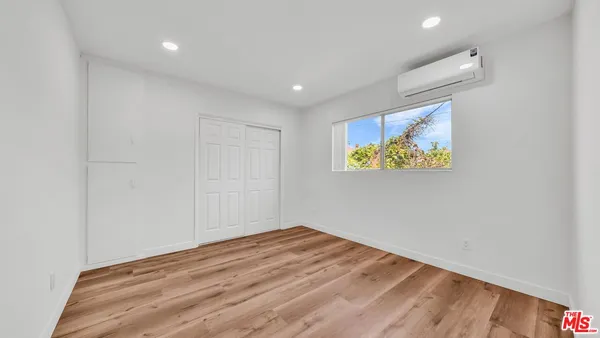 a view of empty room with wooden floor