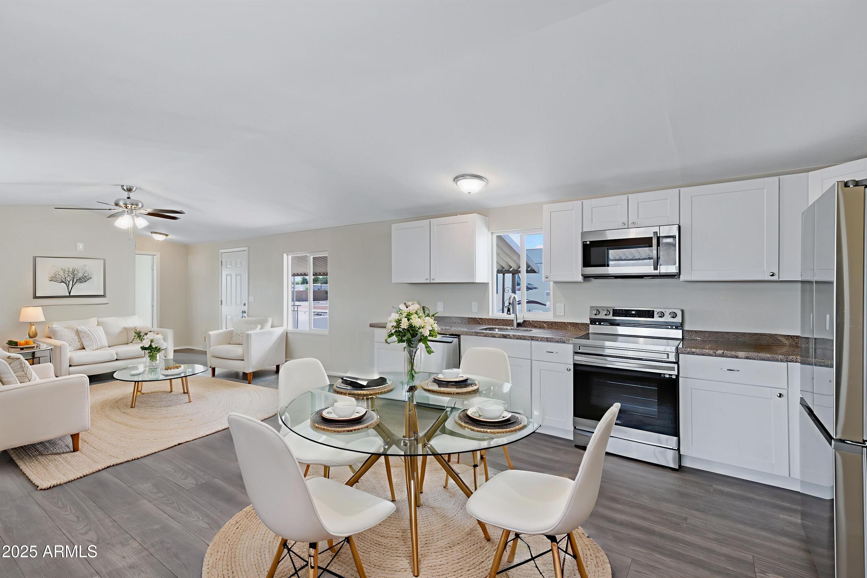 a dining room with kitchen island furniture a wooden floor and a sink