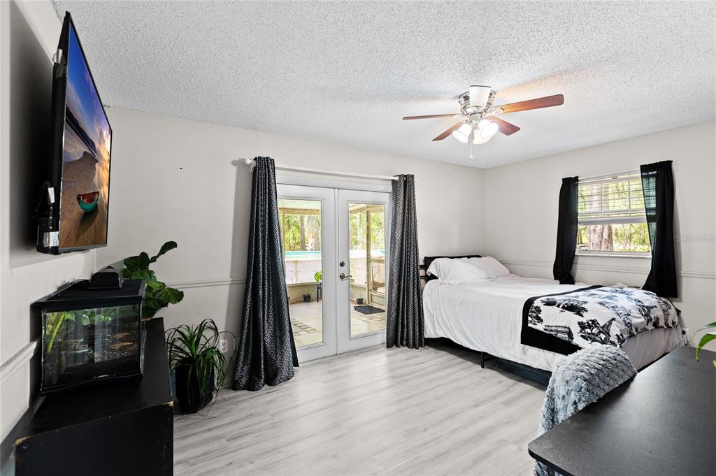 5420 East Gwendolyn Path Inverness, FL 34452 - Photo 14 of 42 a bedroom with a bed wooden floor and a flat tv screen