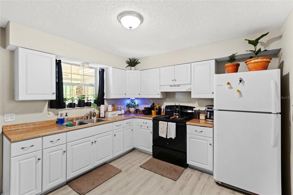 5420 East Gwendolyn Path Inverness, FL 34452 - Photo 10 of 42 a kitchen with white cabinets and white appliances