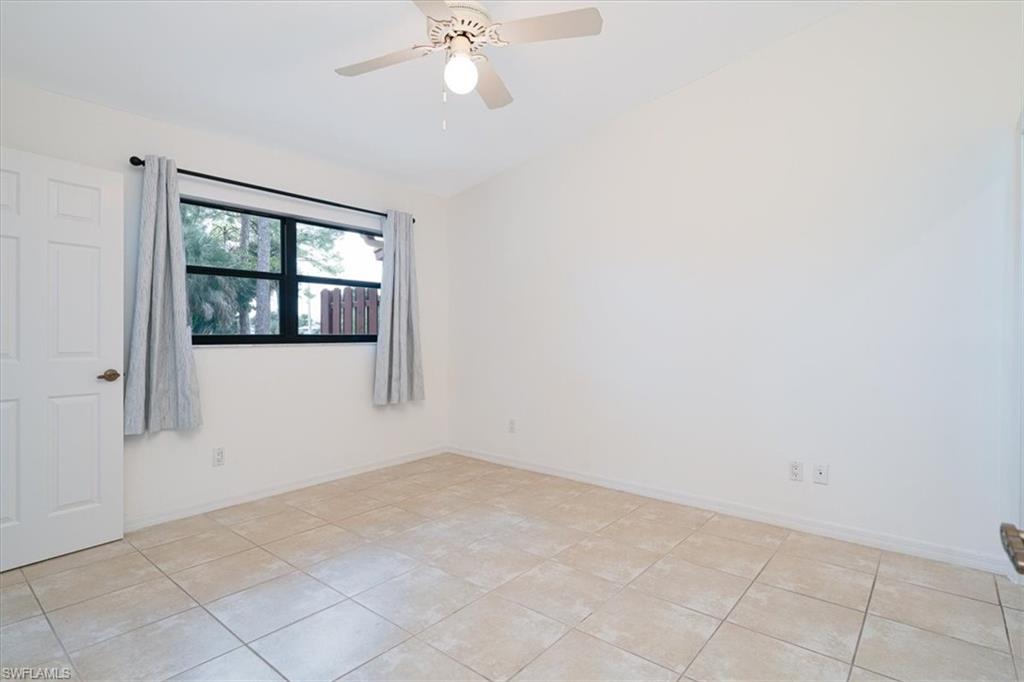 2009 Pine Isle Lane, Unit 2009 Naples, FL 34112 - Photo 11 of 33 an empty room with windows and fan