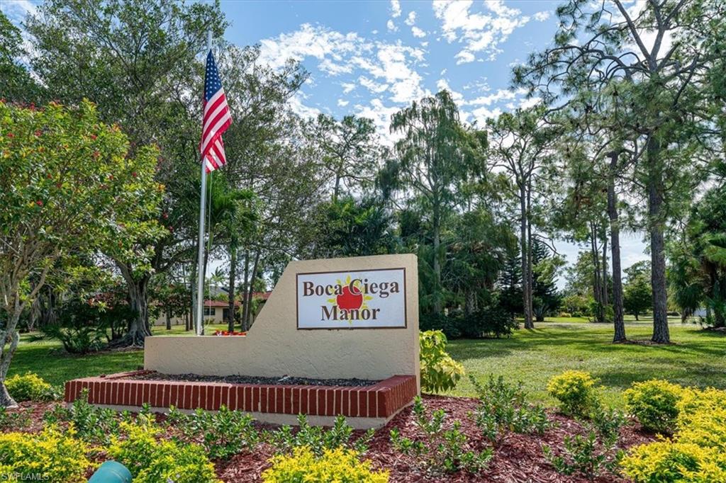 2009 Pine Isle Lane, Unit 2009 Naples, FL 34112 - Photo 21 of 33 a sign that is sitting on a lush green field