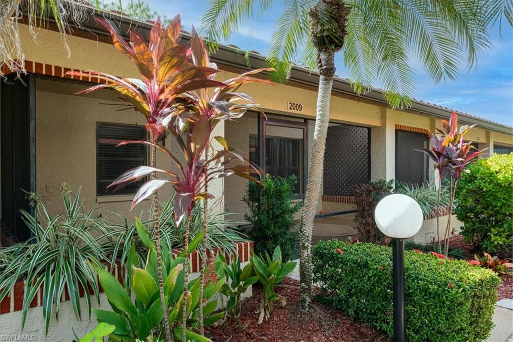 2009 Pine Isle Lane, Unit 2009 Naples, FL 34112 - Photo 22 of 33 a view of a house with a backyard and tree