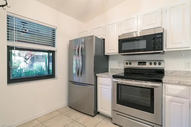 a kitchen with stainless steel appliances white cabinets a stove and a microwave
