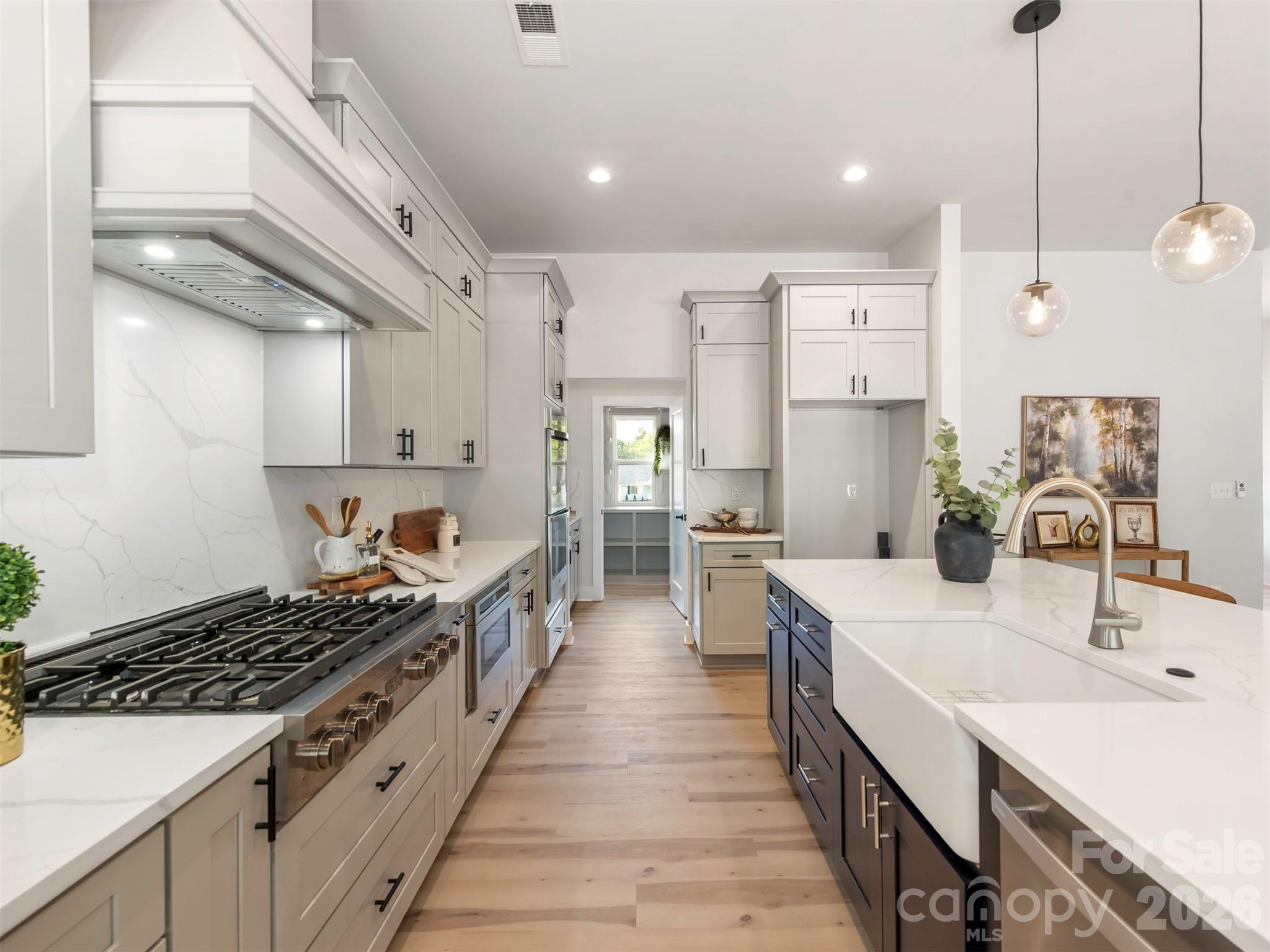 12133 Coyle Road Stanfield, NC 28163 - Photo 13 of 43 a large kitchen with stainless steel appliances a sink a stove and a wooden floors