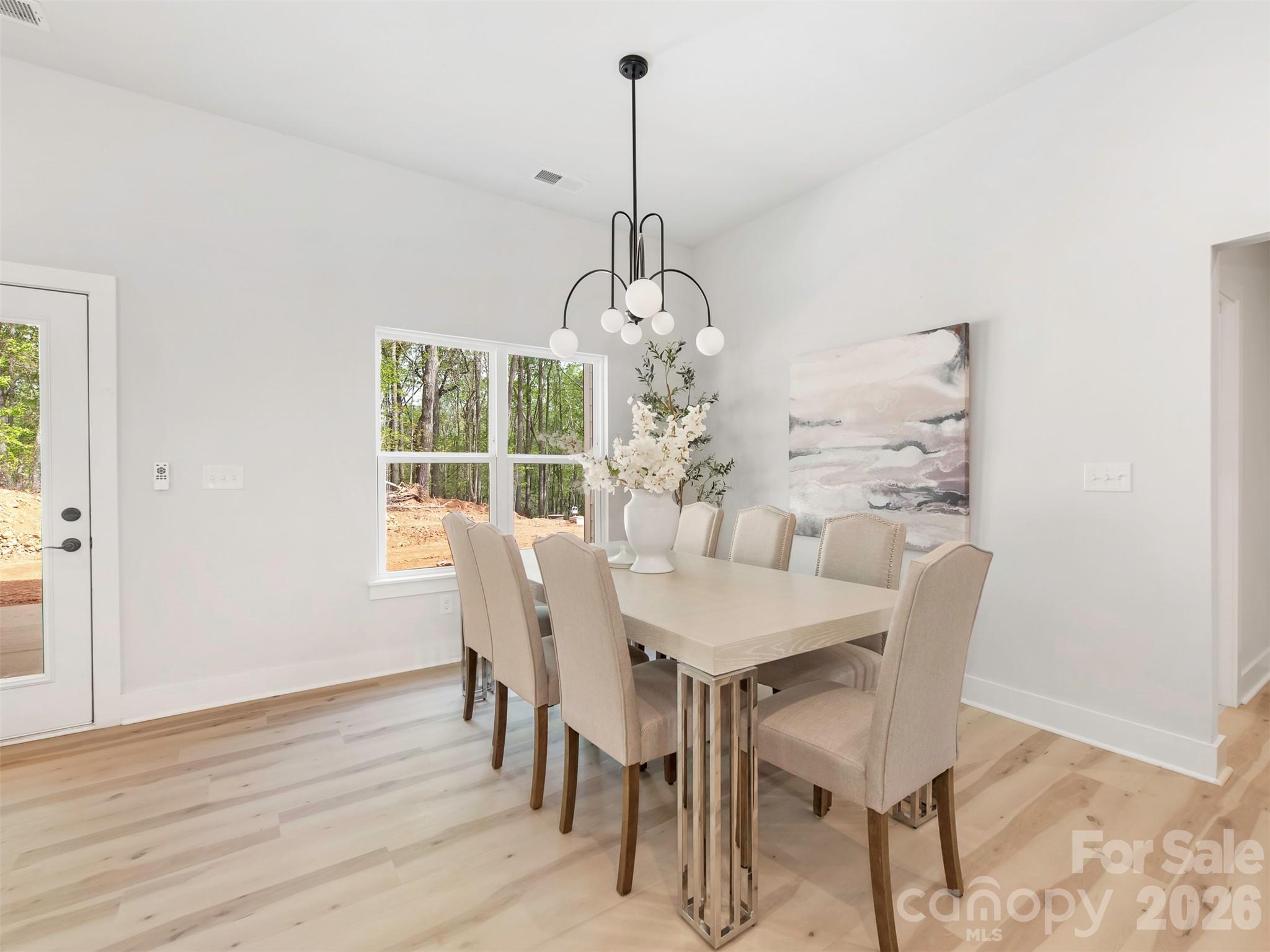 12133 Coyle Road Stanfield, NC 28163 - Photo 16 of 43 a dining room with furniture a chandelier and wooden floor