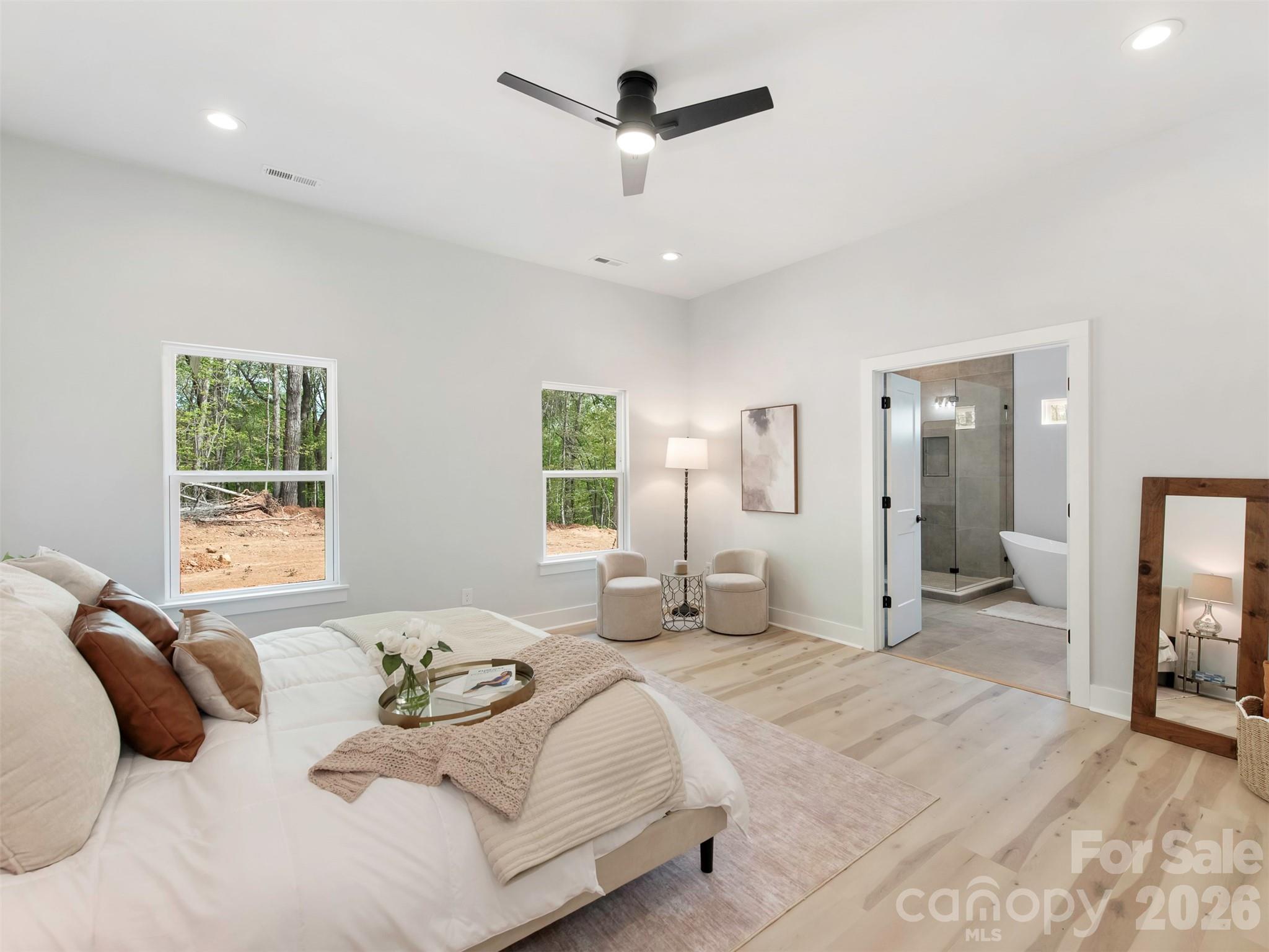 12133 Coyle Road Stanfield, NC 28163 - Photo 18 of 43 a bedroom with a large bed and a chandelier