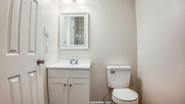 a bathroom with a toilet sink and mirror